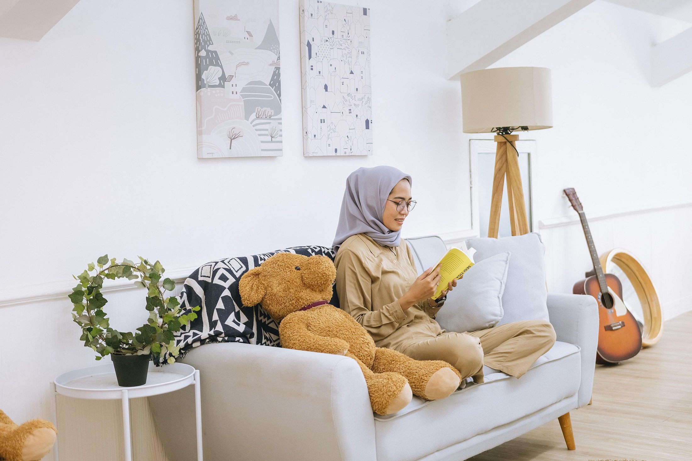 Pregnant woman reading while relaxing at home.