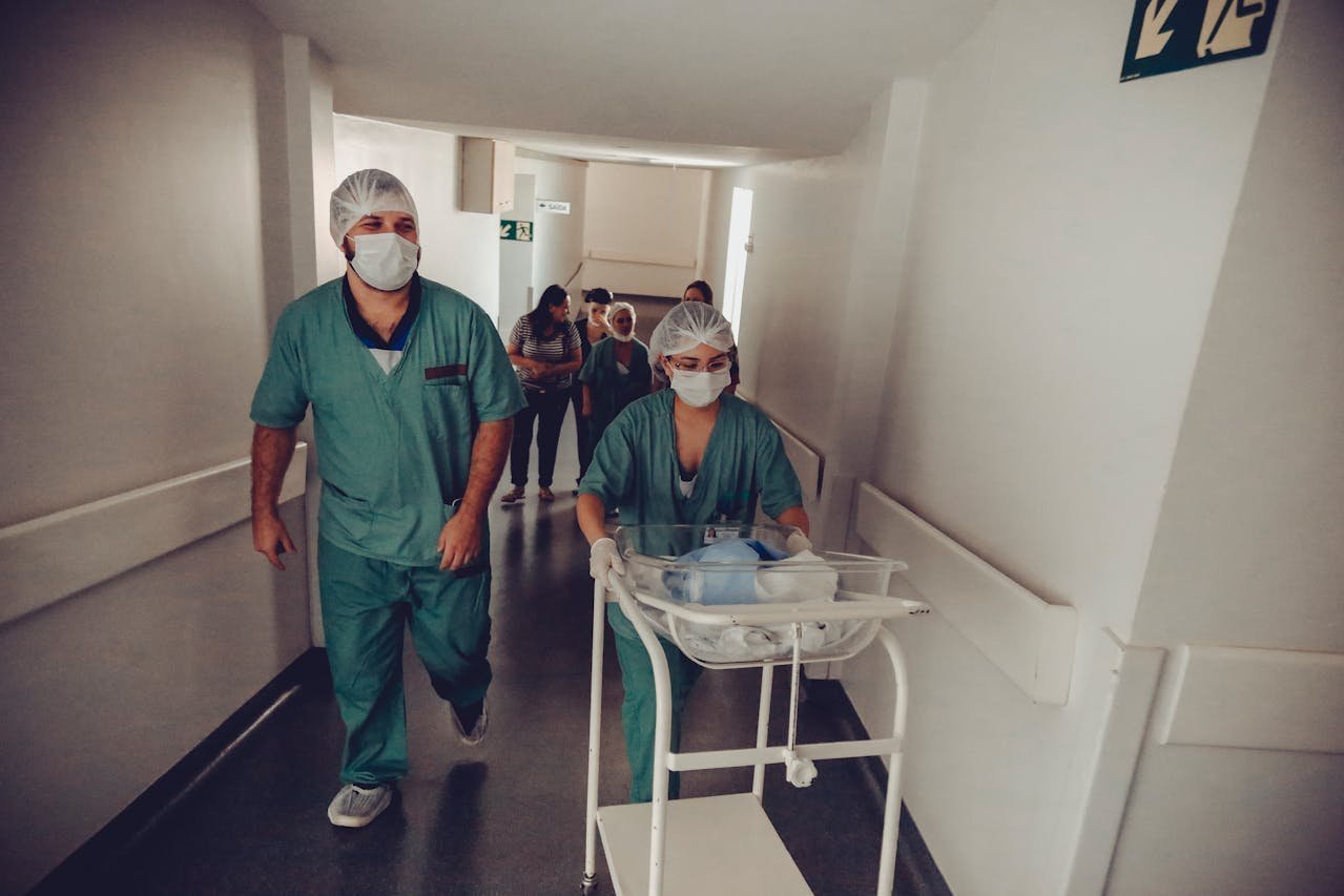 NICU healthcare workers moving a baby in a hospital.