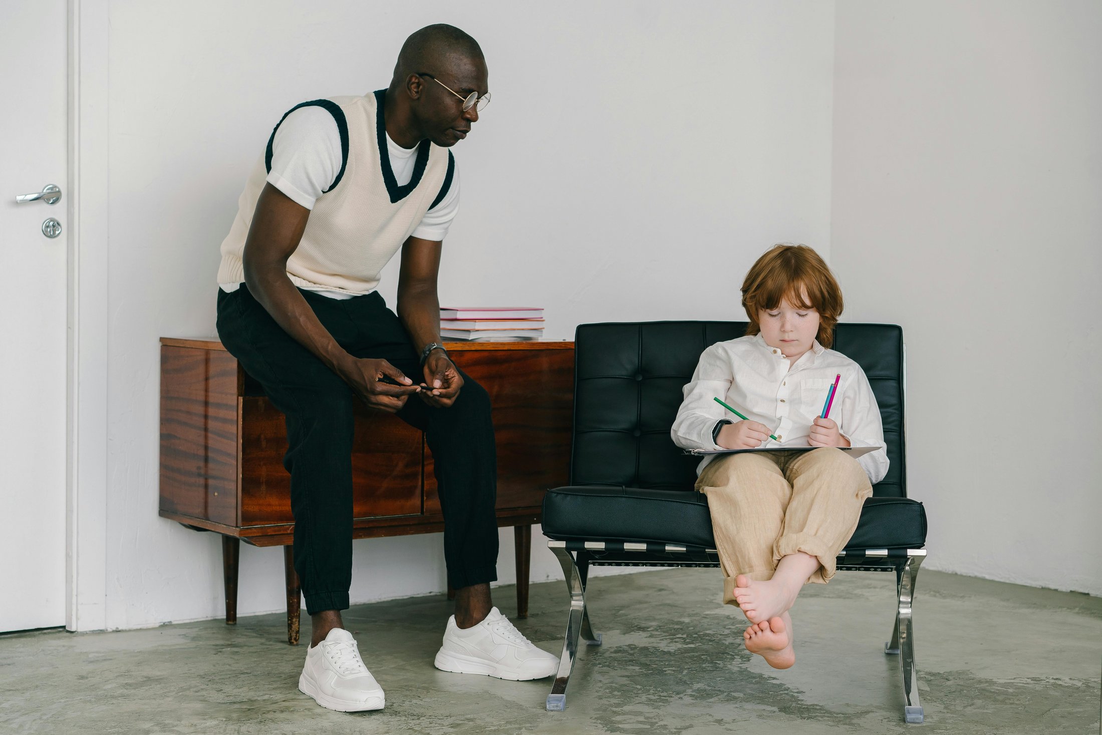 Therapist observing a child drawing during a therapy session.