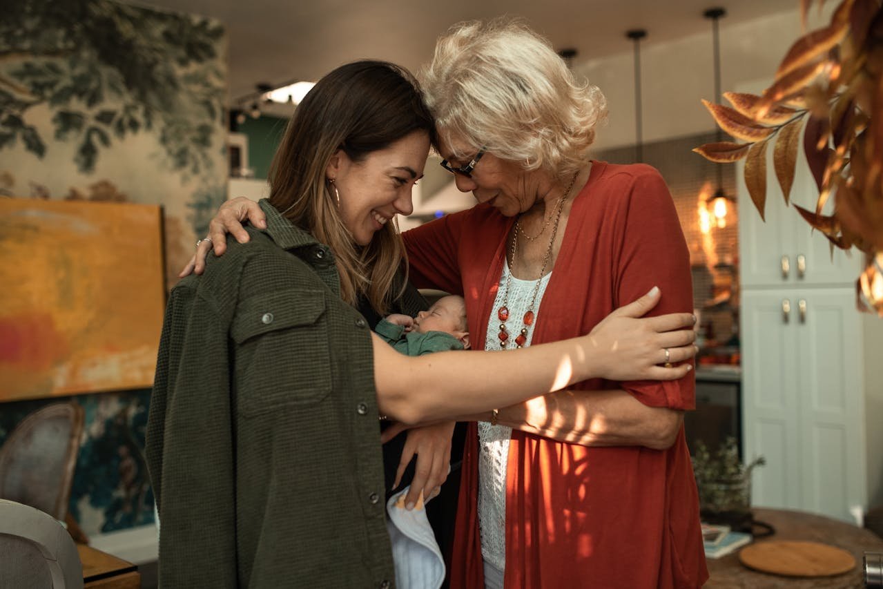 Grandmother and mother bonding with a newborn baby together.
