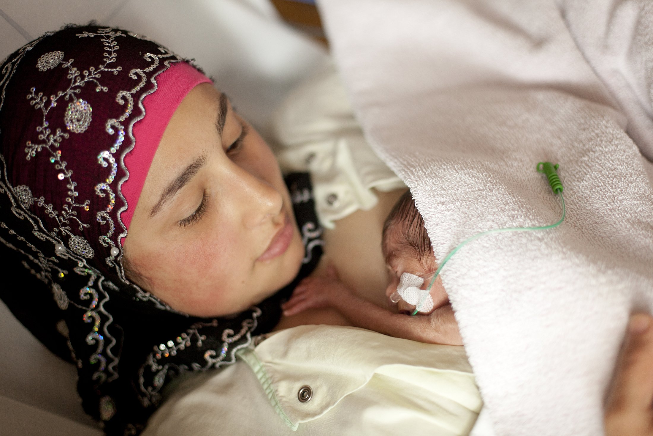 A mother holding her premature baby in skin-to-skin contact.