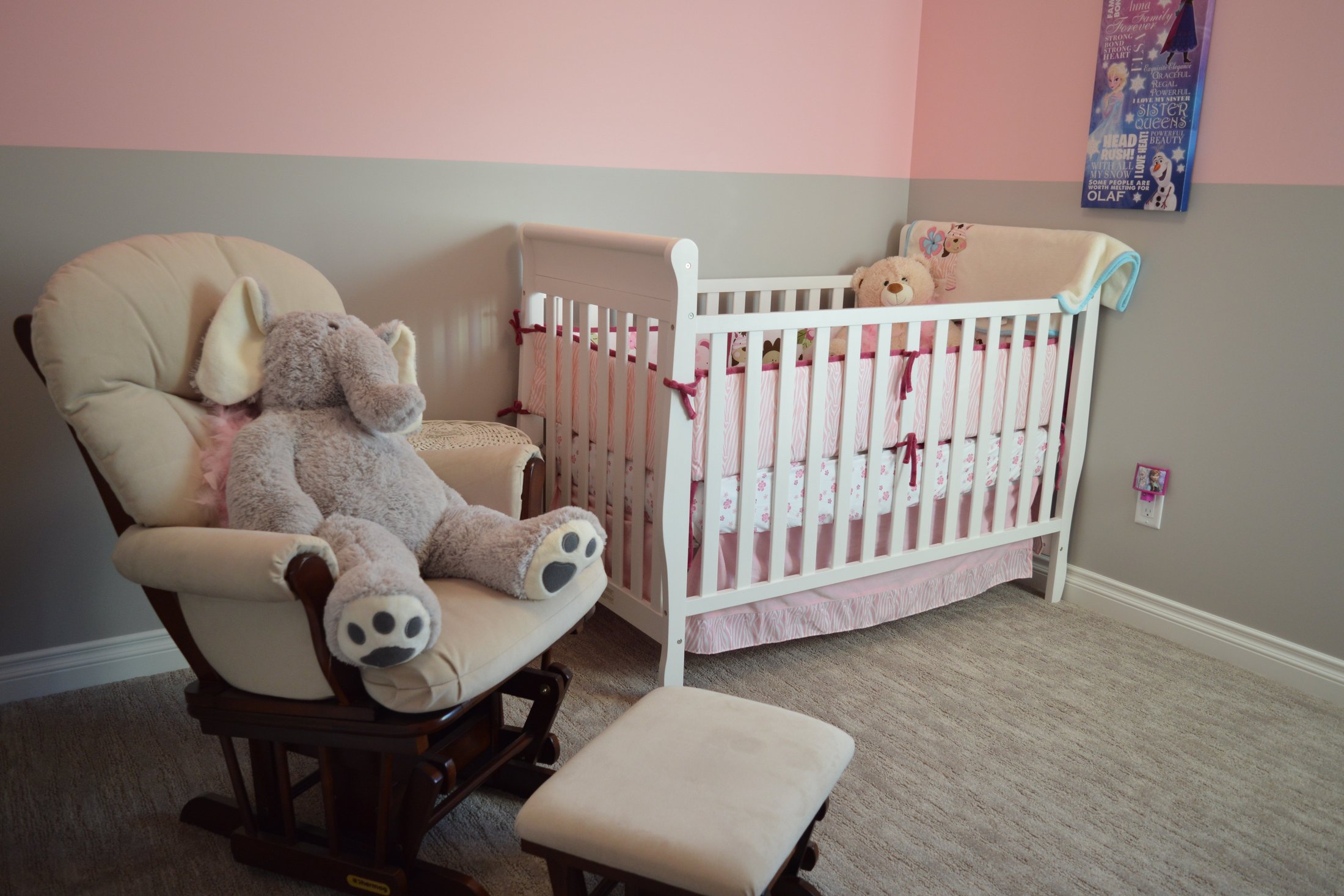 A cosy nursery with a white crib and soft elephant toy ready for a premature baby.
