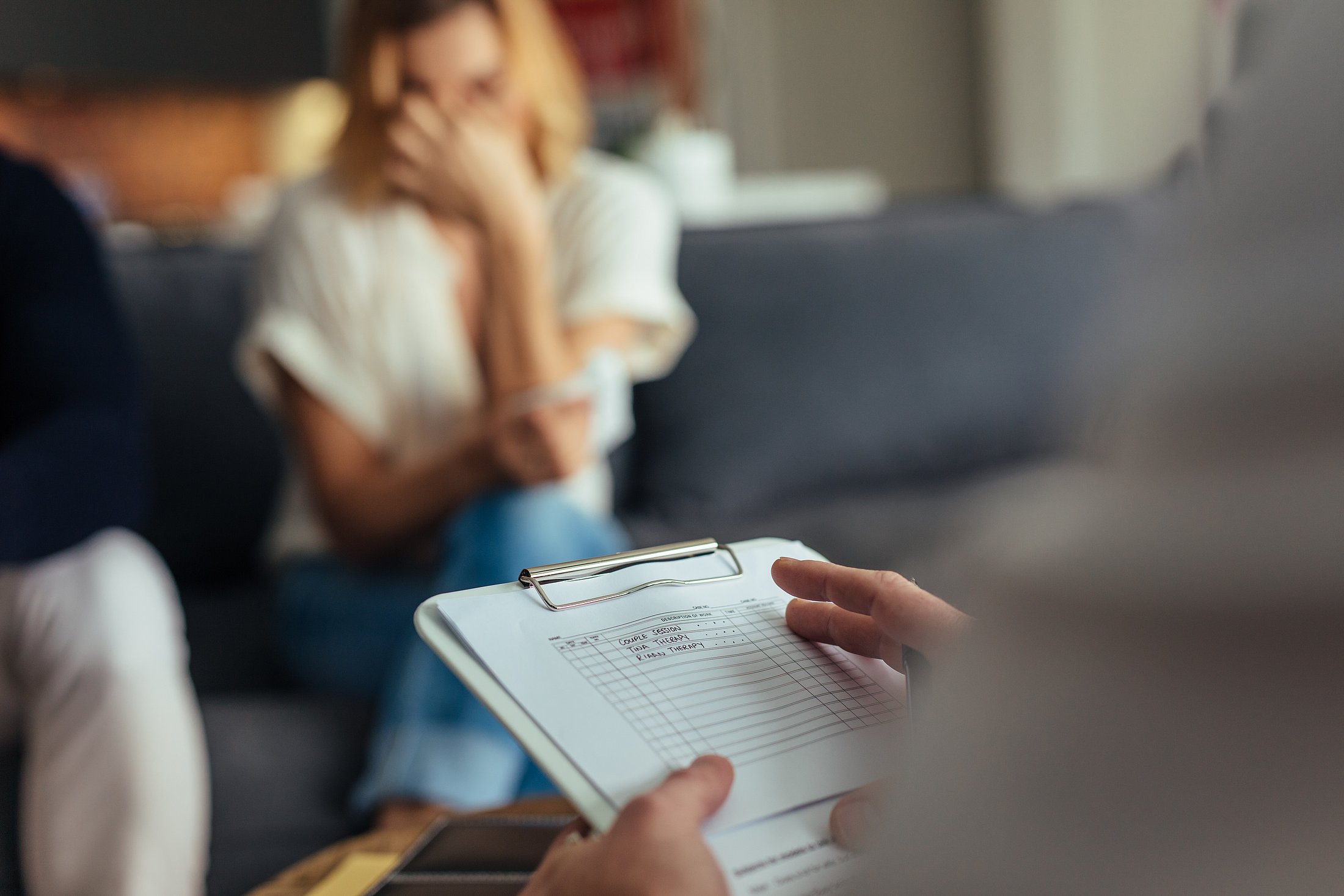 Counsellor taking notes during a family support session.