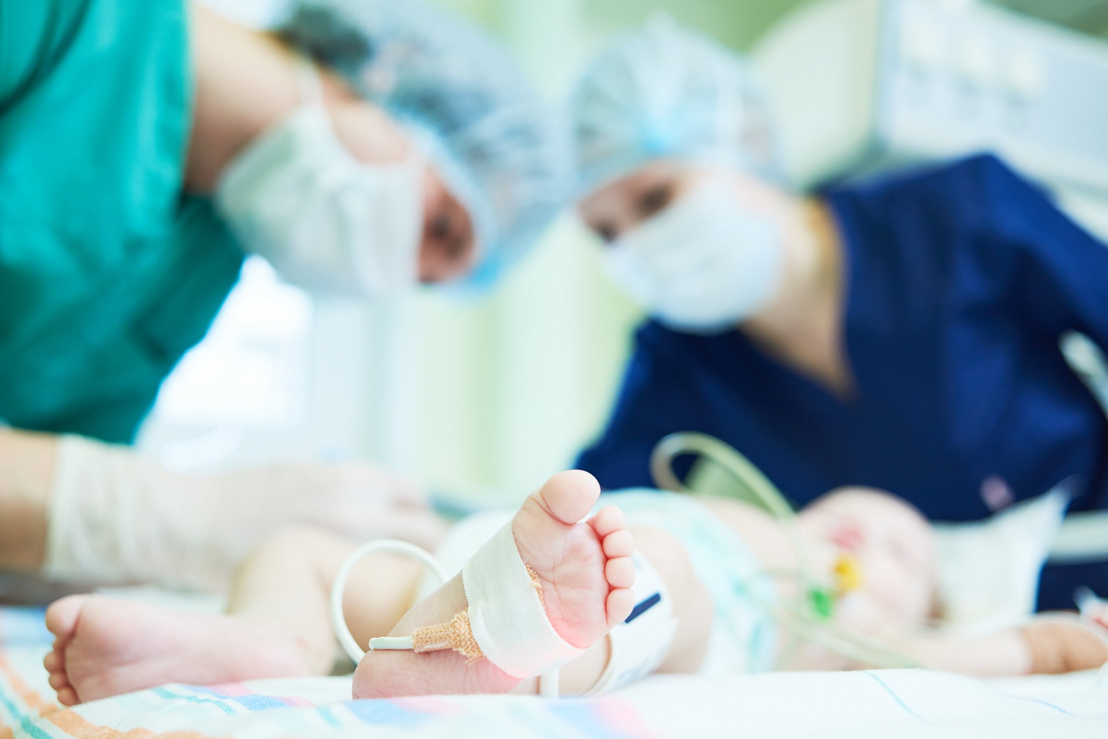 Medical staff attending to a premature baby in intensive care.
