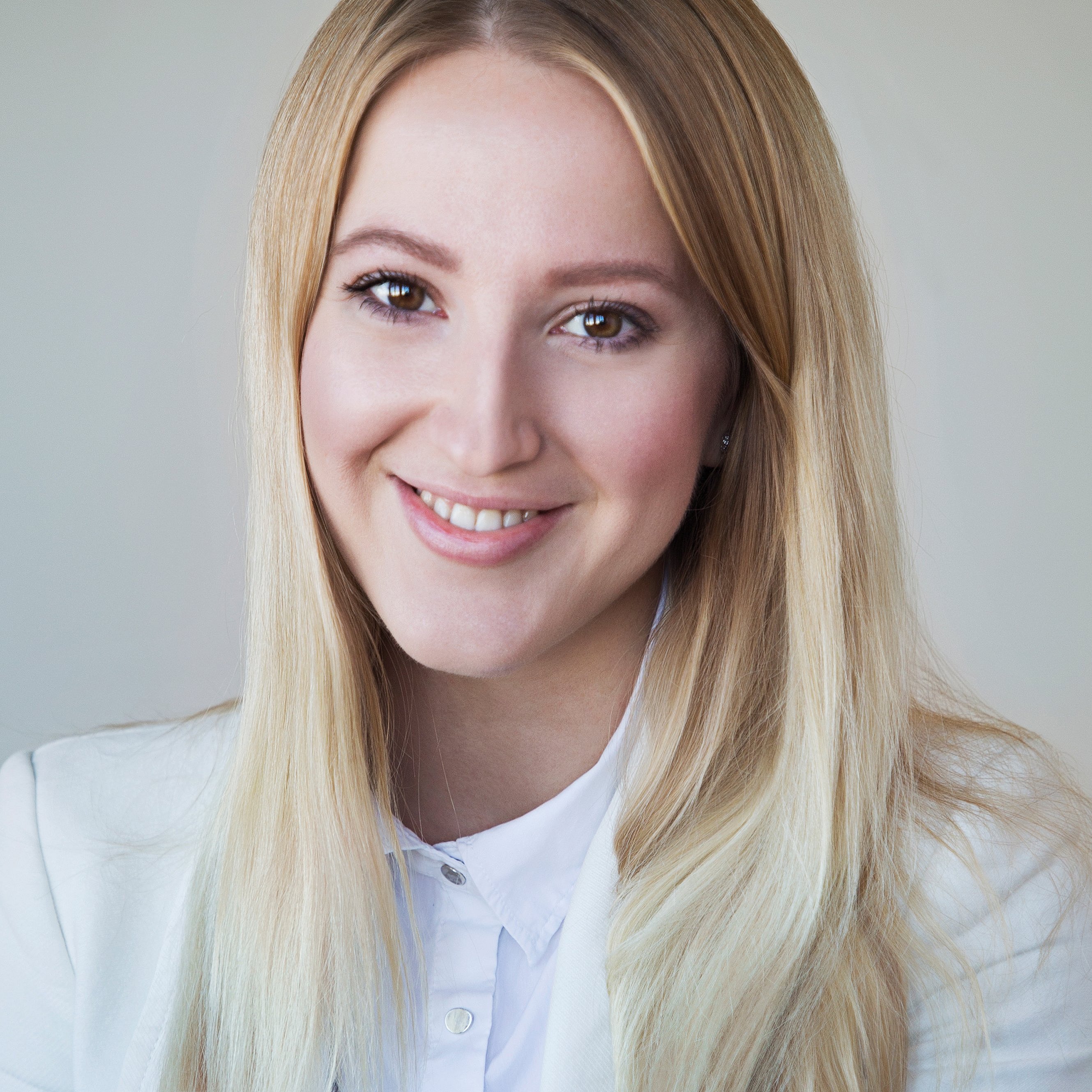A professional headshot of Diana Hofmann-Larina, smiling in a white blazer.