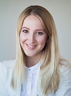 Diana Hoffmann-Larina Portrait A professional headshot of Diana Hofmann-Larina, smiling in a white blazer.