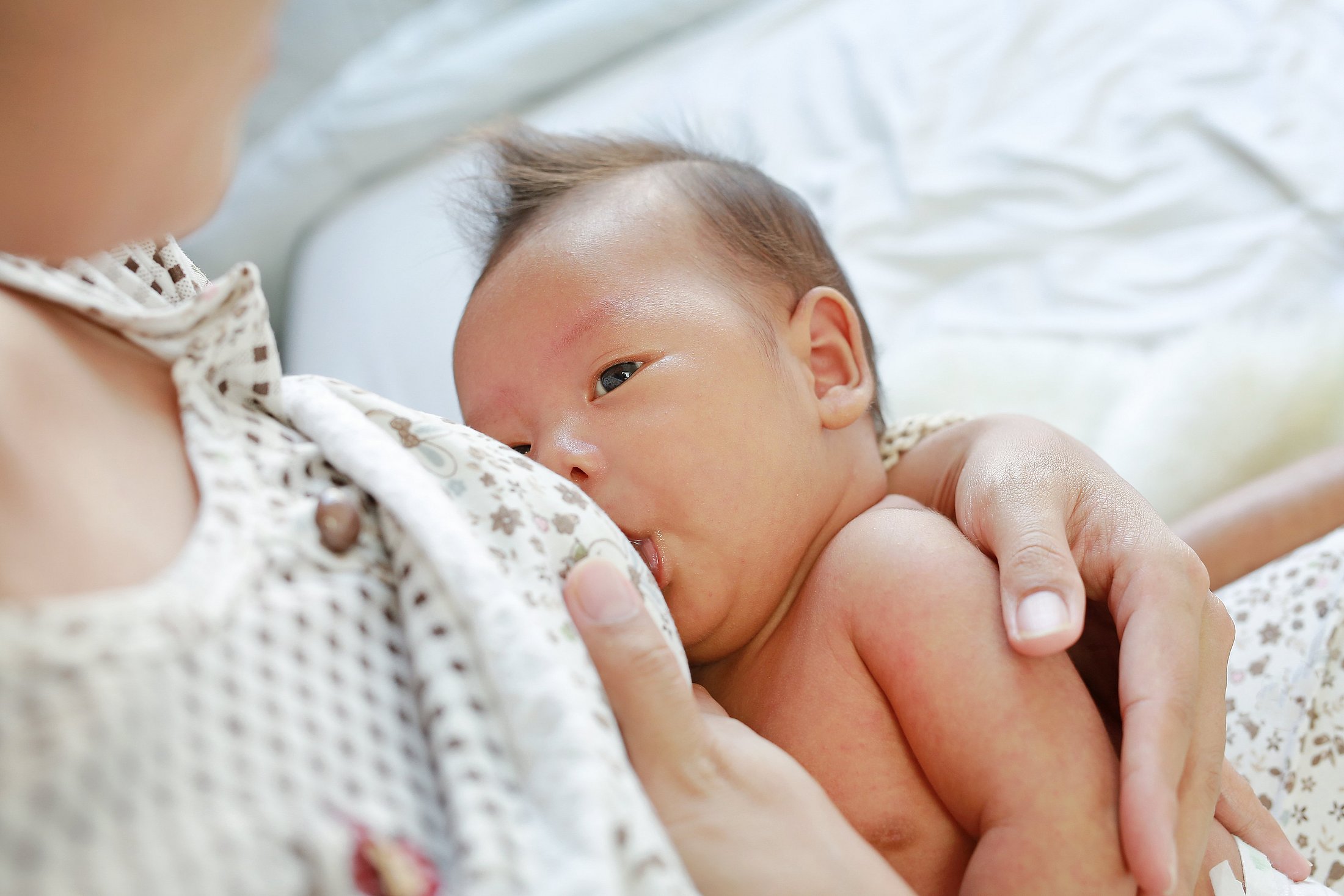 Mother breastfeeding a newborn baby.