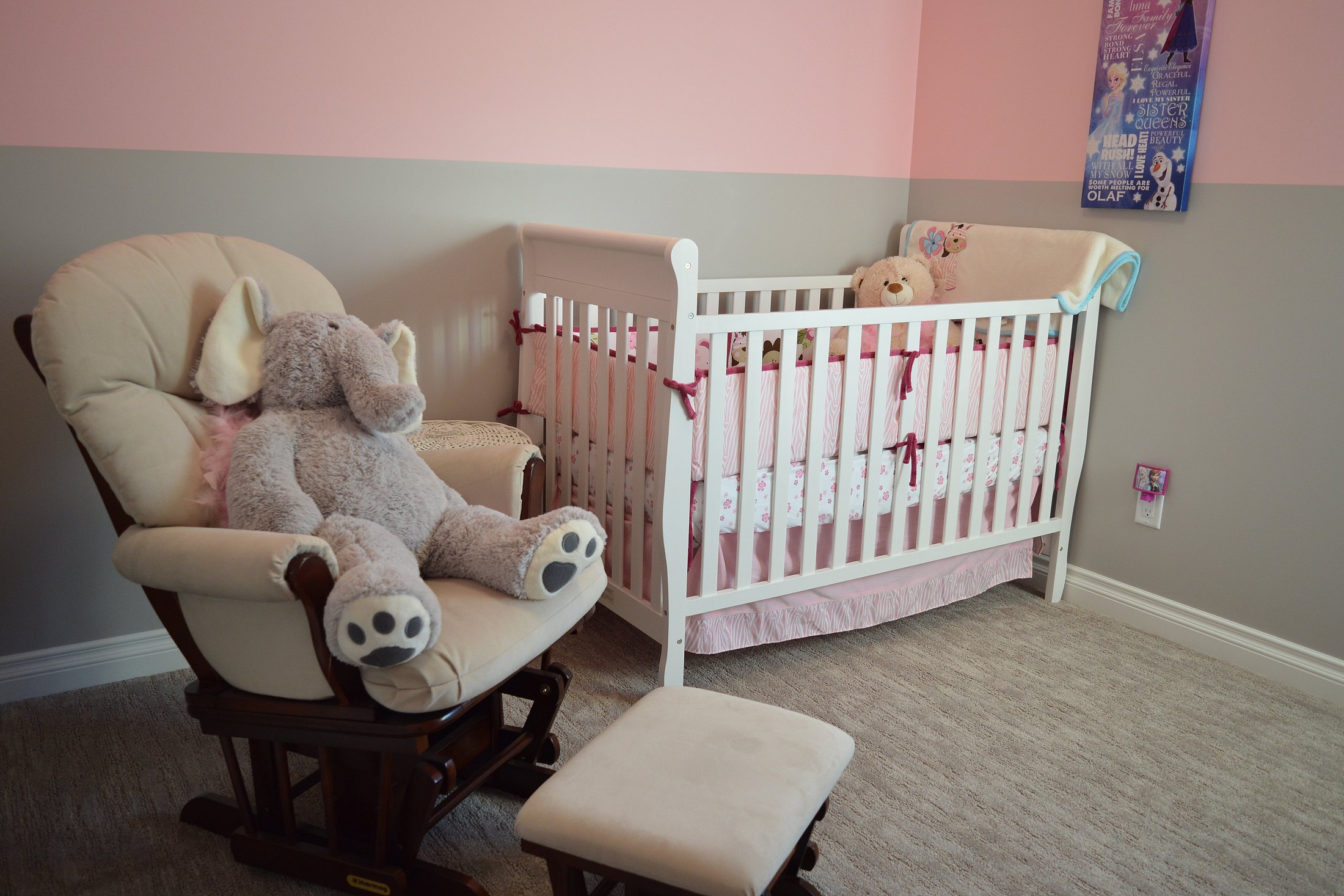 A cosy nursery with a white crib and soft elephant toy ready for a premature baby.
