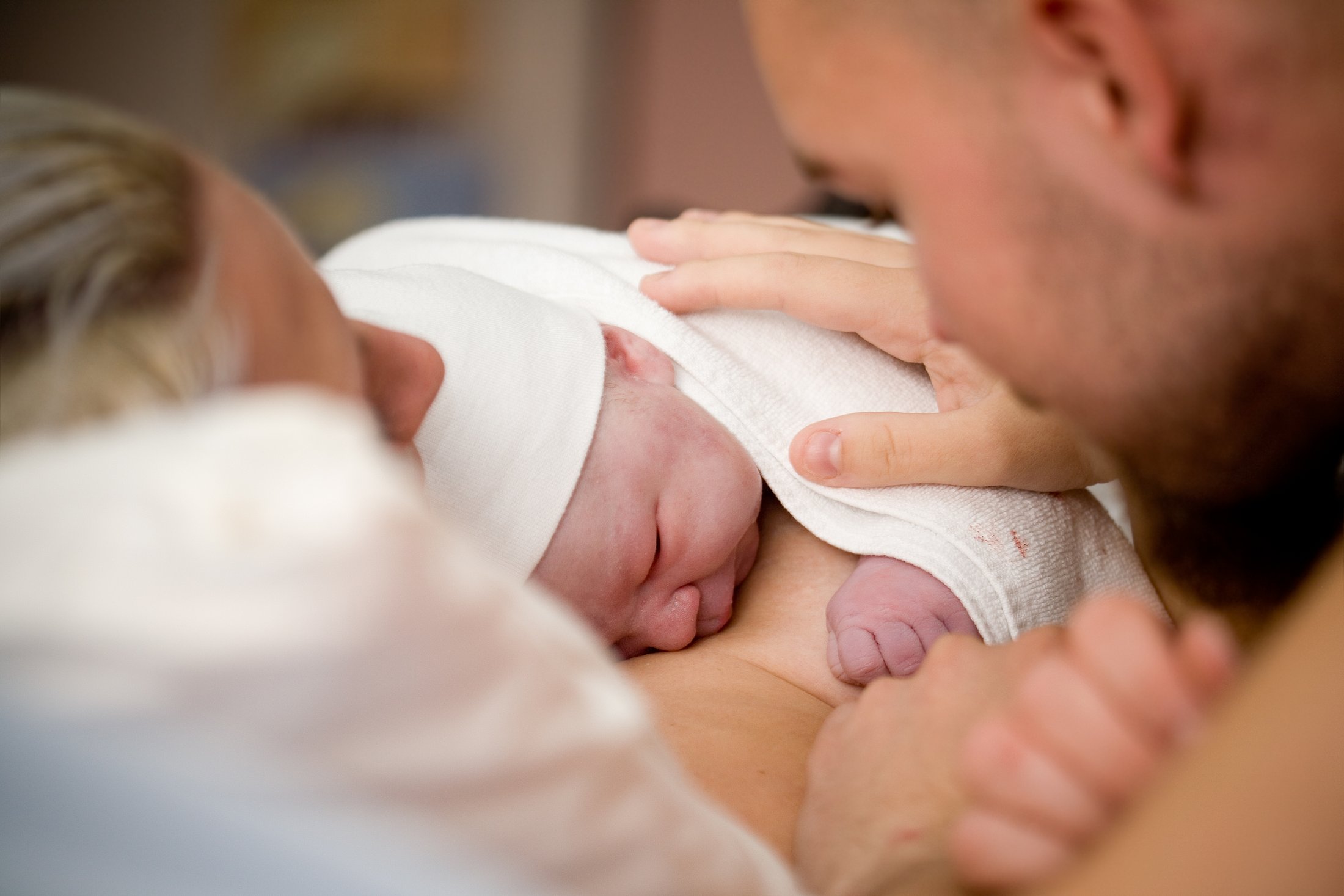 Newborn baby resting skin-to-skin on a parent's chest.