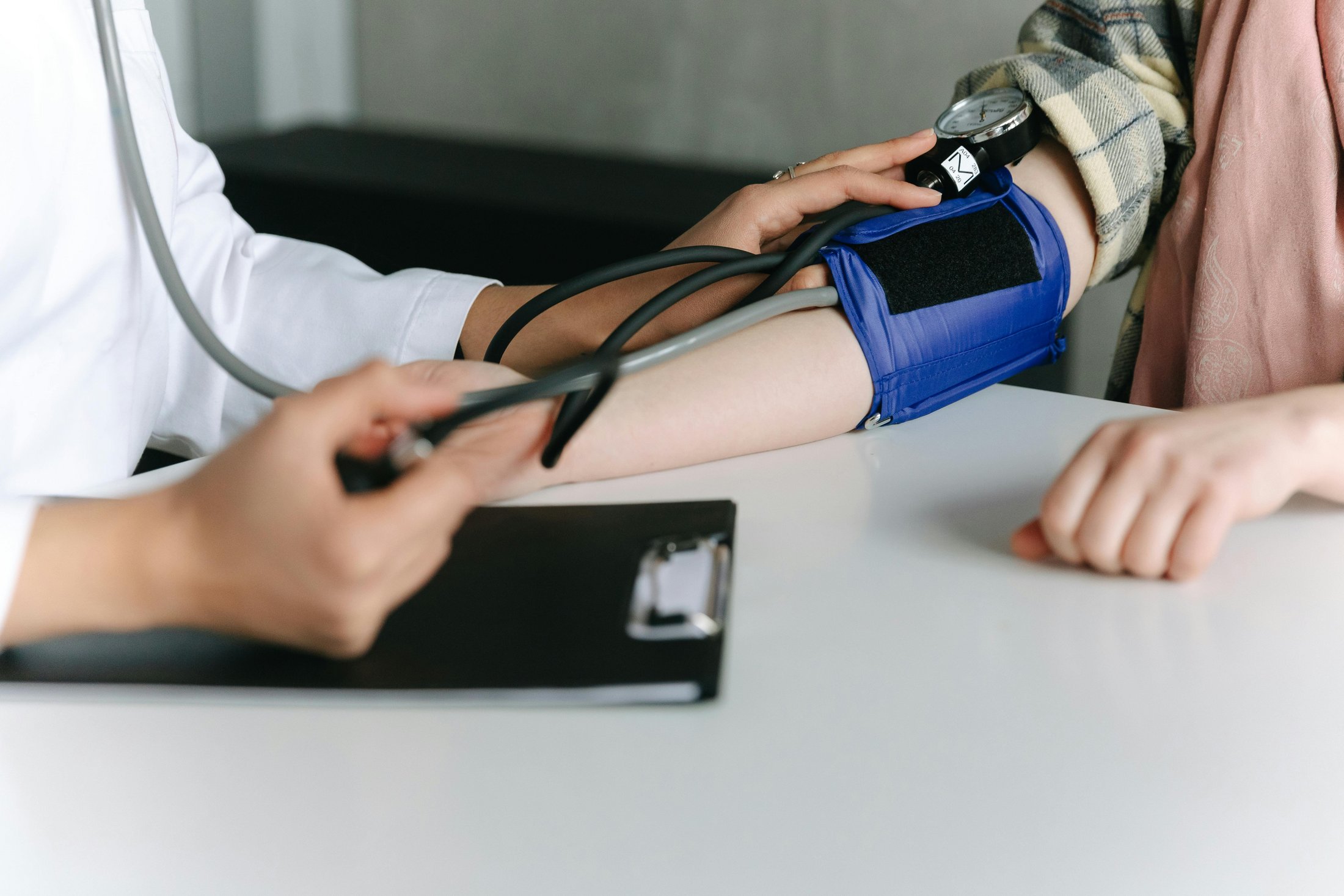 Close-up of a doctor measuring a patient’s blood pressure.