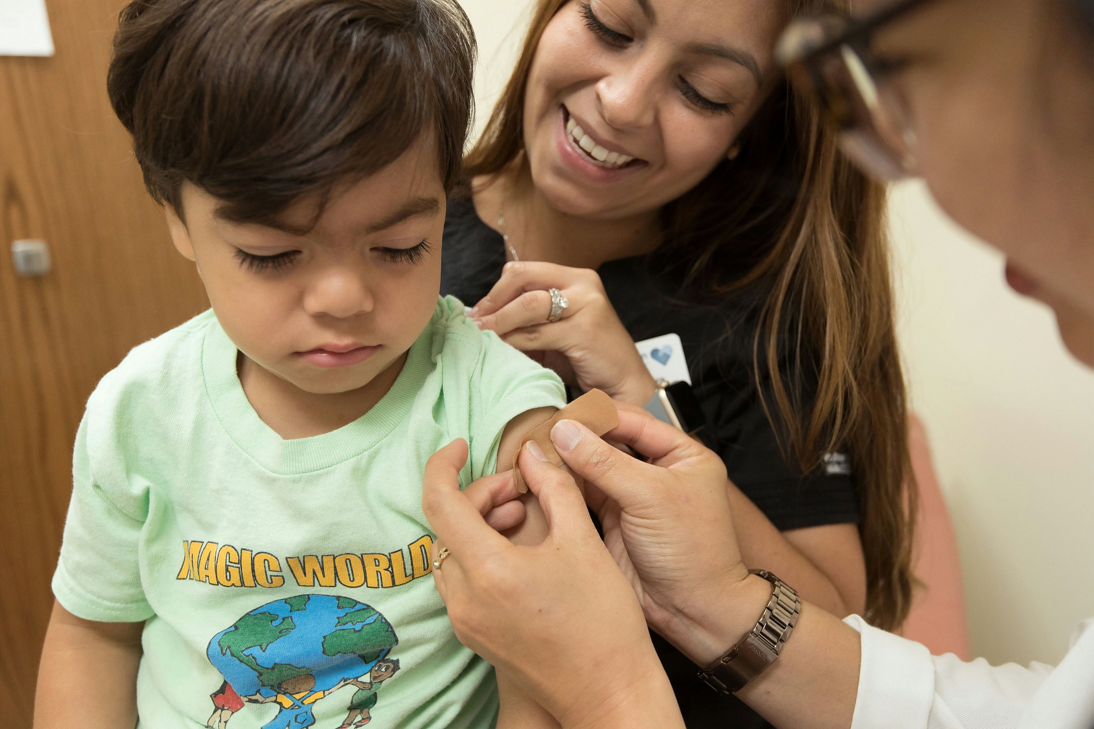 Nurse applying a bandage after a baby’s vaccination.