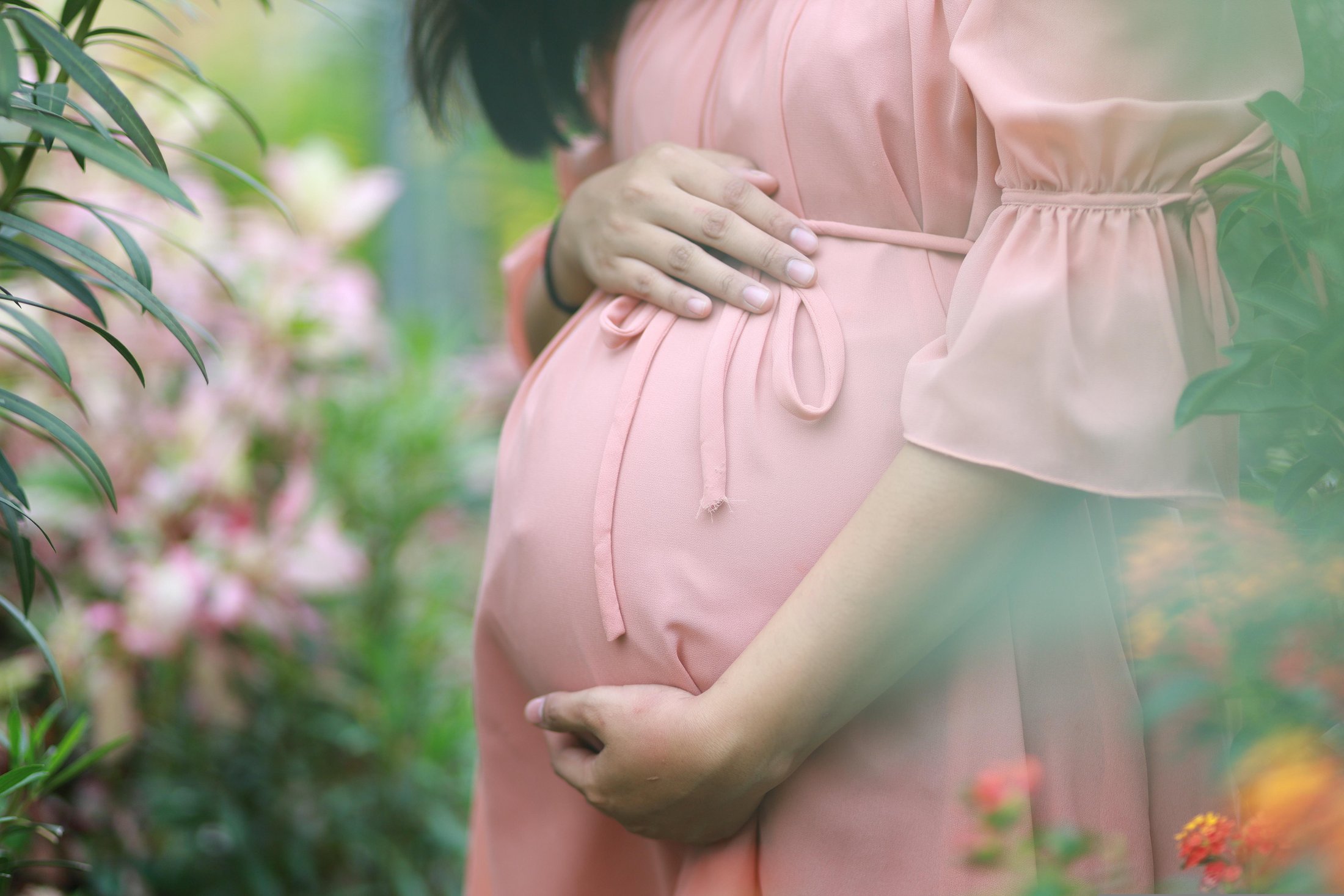 Close-up of pregnant woman holding her belly.