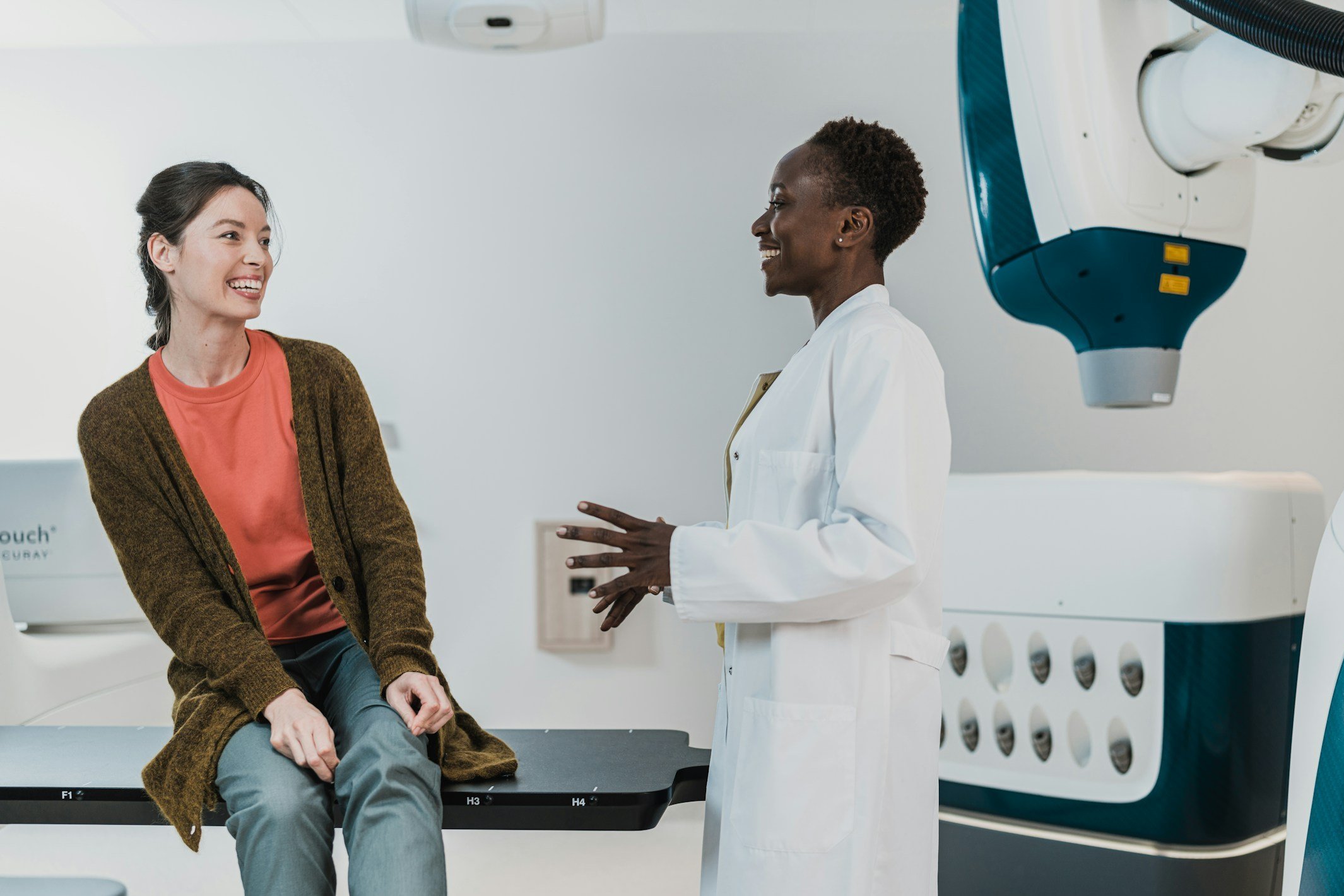 A doctor speaking with a smiling patient in a medical facility.